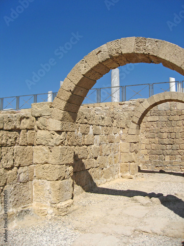 Ancient Roman ruins with stone arch and walls on Caesarea maritima coast  photo