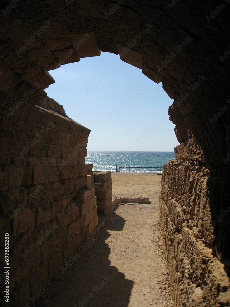 Ancient Roman ruins with stone arch and walls on Caesarea maritima coast 