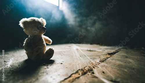 White teddy bear toy sitting alone on the floor in a room of an old abandoned house. Dramatic scary background, copy space for text, darkness horror and freedom concept photo
