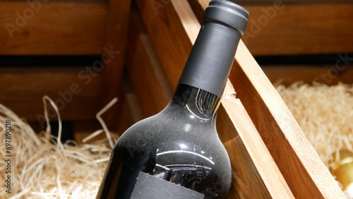 Close-up of a dusty bottle of aged wine in a wooden box photo