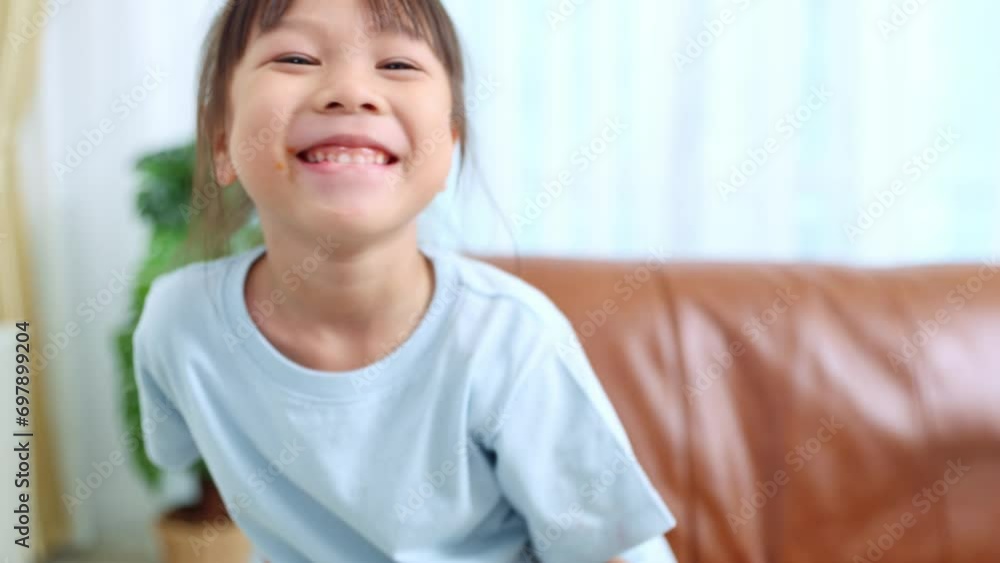 Cheerful small asian girl sits and eats delicious pizza for breakfast. She shows off a slice of pizza in her hand and eats it happily.
Cheerful small asian girl sits and eats delicious pizza for breakfast. She shows off a slice of pizza in her hand and eats it happily.