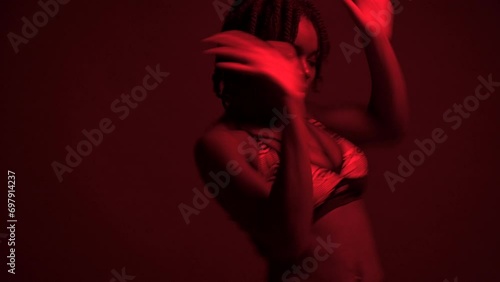 Studio shot of black woman dancing dancehall under neon lights photo