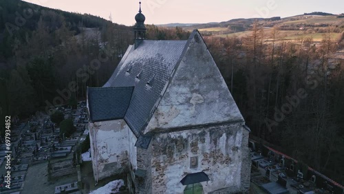 Aerial view of the gothic church in Velhartice and the surrounding sunlit hilly landscape. photo