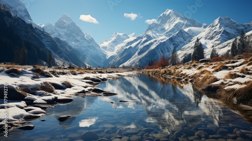 A serene winter scene unfolds in this image, encompassing snowy mountains, a serene river, and lush trees flanking its sides under a clear blue sky photo