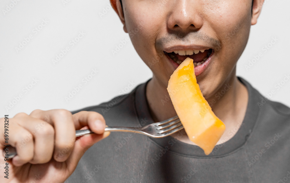 Close up of man eating cantaloupe with fork. Close up of man eating cantaloupe with fork.