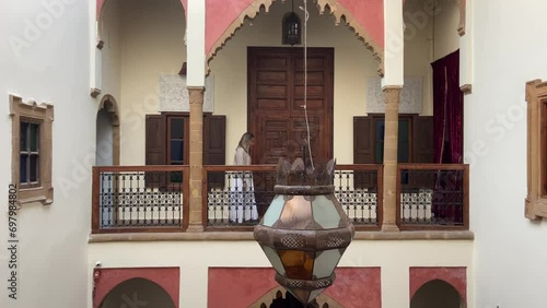 Caucasian blonde tourist woman walking through moroccan Riad rooms