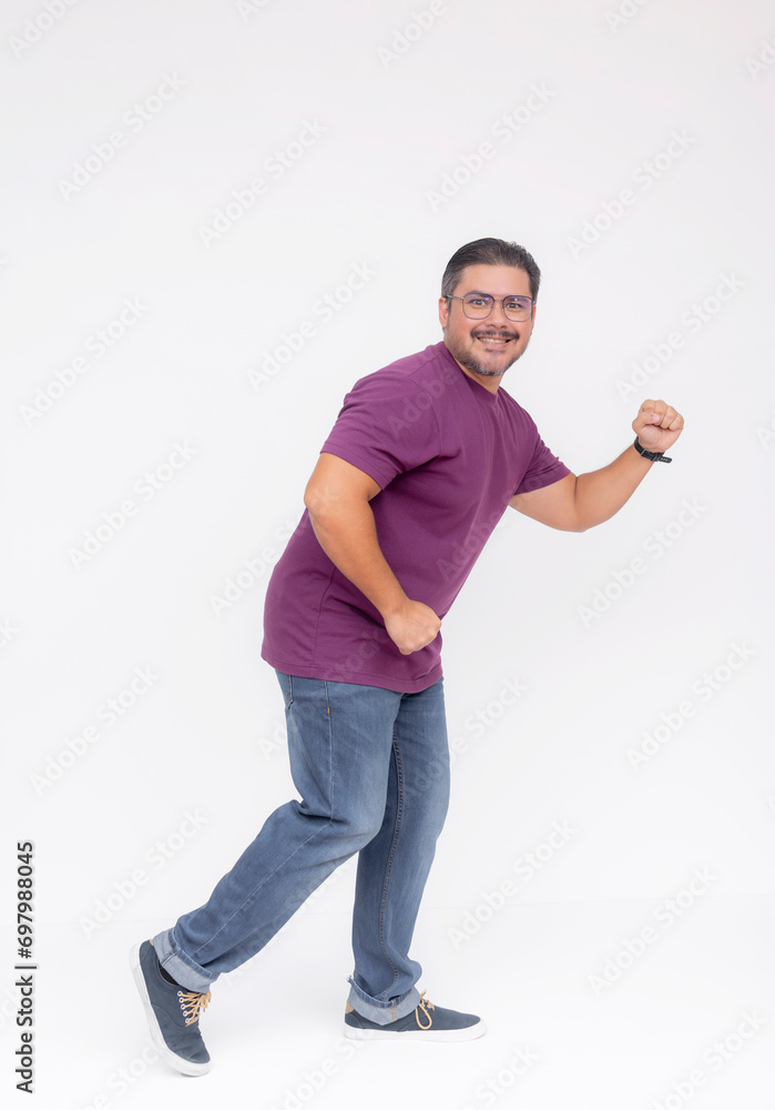 A middle aged bearded man looking at the camera while walking to the right in a comical fashion. Wearing a purple waffle shirt and jeans. Full body photo, isolated on a white background. A middle aged bearded man looking at the camera while walking to the right in a comical fashion. Wearing a purple waffle shirt and jeans. Full body photo, isolated on a white background.