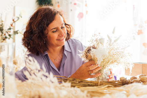 Delighted specialist creating flower composition in floral store