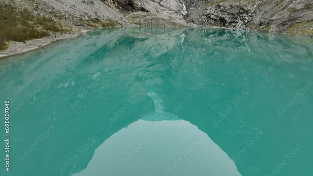 aerial view over blue lake towards briksdalsbreen glacier in norway with reflecting mountains in water aerial view over blue lake towards briksdalsbreen glacier in norway with reflecting mountains in water