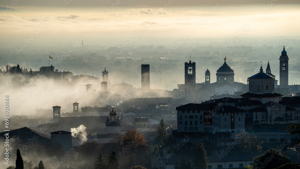 Bergamo, Italy. Amazing aerial landscape of the fog rises from the plains and covers the old town during sunrise. Bergamo one of the most beautiful city in Italy