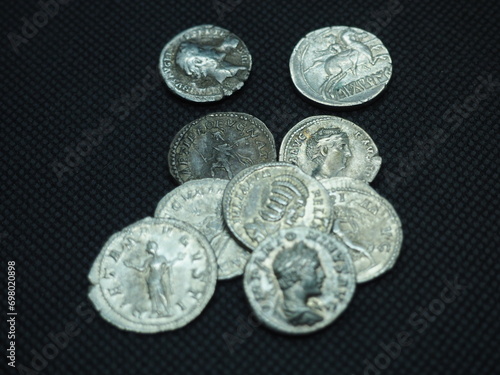 Roman gold and silver coins on a black background