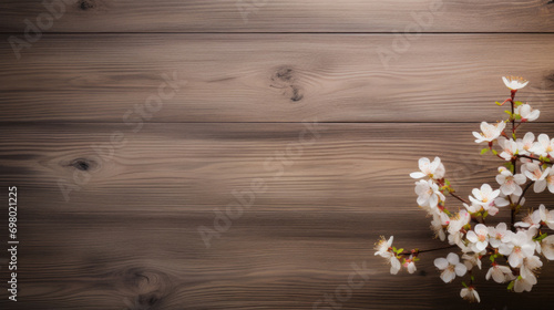 Delicate white spring blossoms adorn a dark wooden background, offering a contrast of color and texture. © tashechka