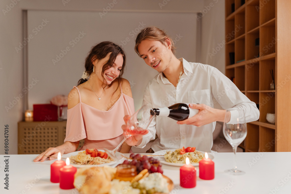 Smiling romantic couple drinking wine, eating food celebration Valentines day or birthday at home. Smiling elegant man and woman sitting in restaurant. Dating, love, romantic dinner Smiling romantic couple drinking wine, eating food celebration Valentines day or birthday at home. Smiling elegant man and woman sitting in restaurant. Dating, love, romantic dinner