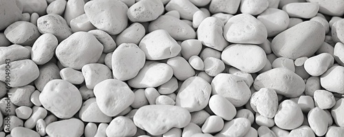 Collection of various rocks and pebbles. Smooth white stones with intricate patterns create abstract and soothing composition. Light and shadow enhances texture and depth to arrangement