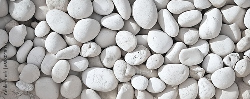 Collection of various rocks and pebbles. Smooth white stones with intricate patterns create abstract and soothing composition. Light and shadow enhances texture and depth to arrangement photo