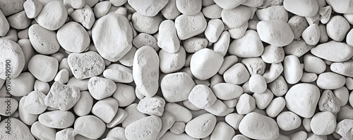 Collection of various rocks and pebbles. Smooth white stones with intricate patterns create abstract and soothing composition. Light and shadow enhances texture and depth to arrangement