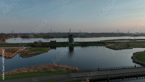 Drone footage of Twiskemolen mill on Zuidwestplas lake at sunset in Landsmeer, Netherlands photo