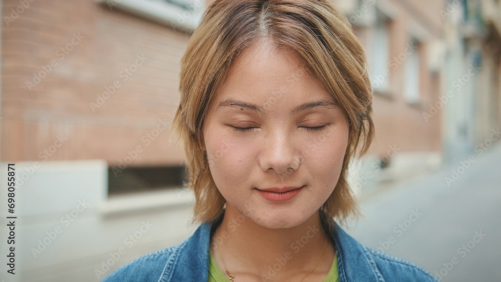 Close-up of young smiling woman with eyes closed while standing on the street Close-up of young smiling woman with eyes closed while standing on the street
