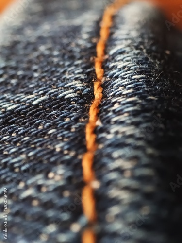 Macro detail of sewing blue jeans