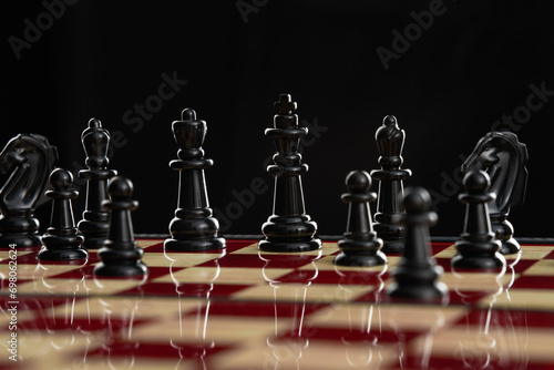 Close-up of the black king and queen pieces in an open position on a chessboard.