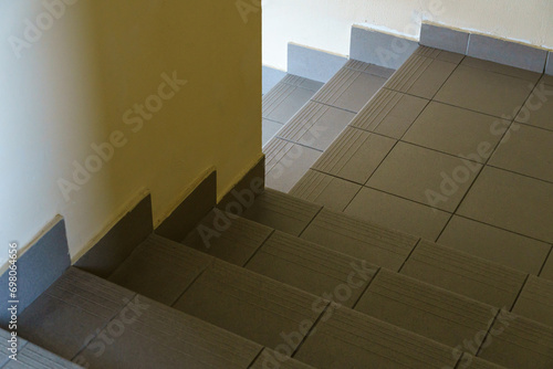A narrow staircase in an office building. Modern interior of the lobby of an office building with tiles on the floor.