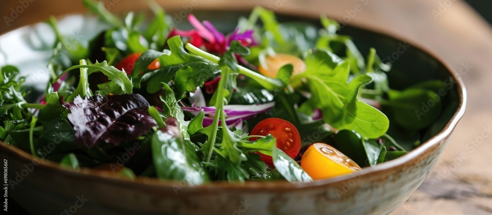Close-up of a bowl with a fresh mixed green salad. Close-up of a bowl with a fresh mixed green salad.