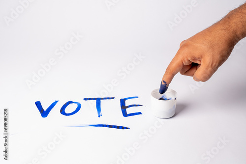 photo of blue finger in Election ink bottle 