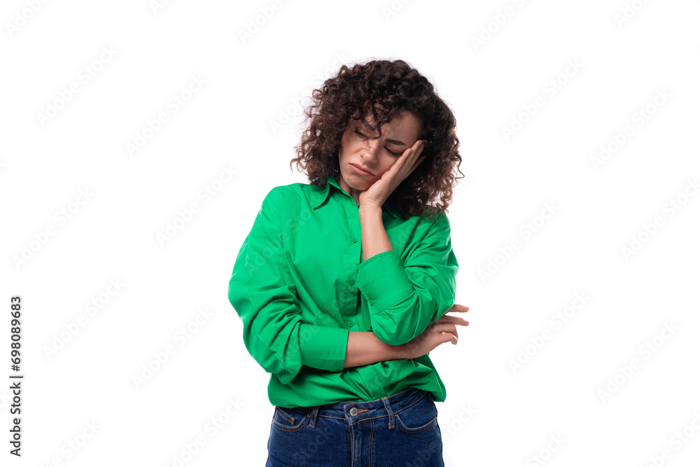 young stylish caucasian brunette woman with curled hair dressed in a green shirt feels tired young stylish caucasian brunette woman with curled hair dressed in a green shirt feels tired