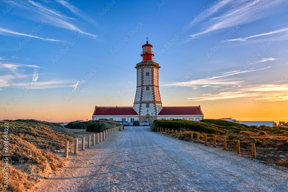 Portuguese lighthouse and road to it at beautiful sunset, cape