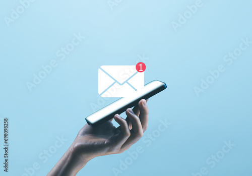 hand holding the smartphone shows the icon for new email, send an information message email. smart SMS mail on digital. business communication contact newsletter concept. marketing social media. photo