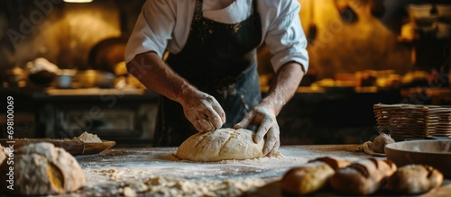 Male baker kneading dough to make bread. photo