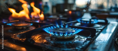 Calculating electricity expenses for gas stove usage with blue flame on steel panel.