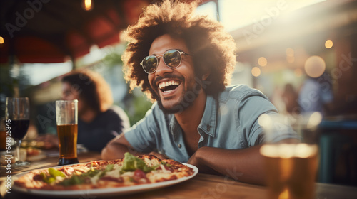 Young man standing in front of pizza at the table in a pizzeria photo