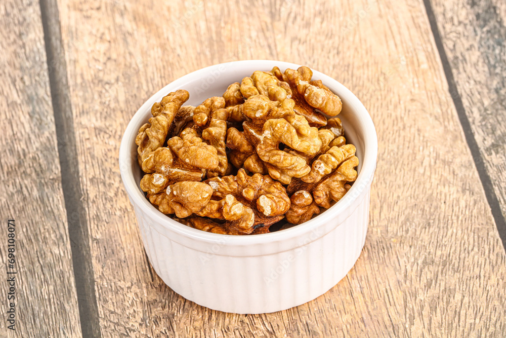Cracked unshelled walnut in the bowl Cracked unshelled walnut in the bowl