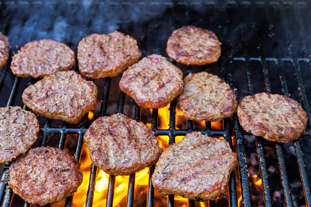 Grilling beef meat barbecue burgers on the barbecue grill using fire flame Grilling beef meat barbecue burgers on the barbecue grill using fire flame