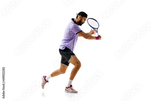 Concentrated competitive young man, tennis player in motion during game, playing isolated over white background. Concept of professional sport, movement, competition, action. Ad photo
