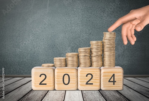 flipping year wooden block and Coins stack.