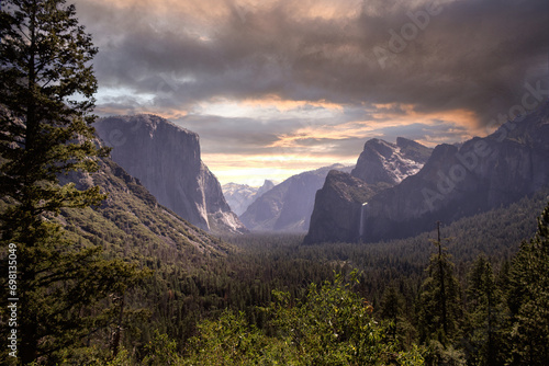 Yosemite Valley under stormy sunset. the lush green valley of the Sierra Mountains sprawls out into the narrow mountain pass in northern California