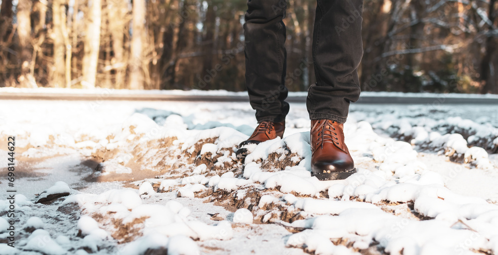 A man in new boots walks along a snowy road A man in new boots walks along a snowy road