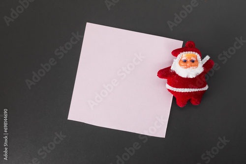 Santa Claus with blank paper on black background. Christmas and New Year concept.