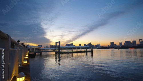 夕暮れ時のお台場の船着場と東京湾と東京の高層ビル群 photo