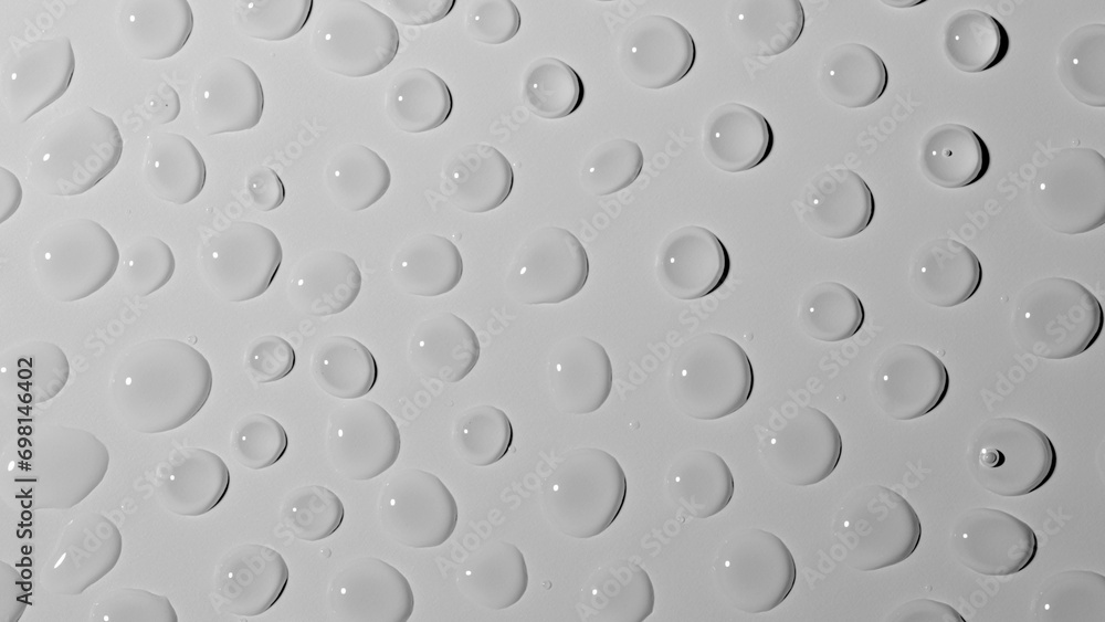 Many large shiny water droplets on glass on white studio background. Water splashes of rain. Aqua particle creative advertising concept. Many large shiny water droplets on glass on white studio background. Water splashes of rain. Aqua particle creative advertising concept.