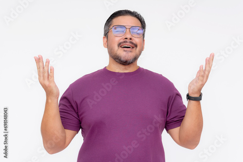 A religious middle aged man sings the Lord's prayer, raising his hands up. Wearing a purple waffle shirt, Isolated on a white background.