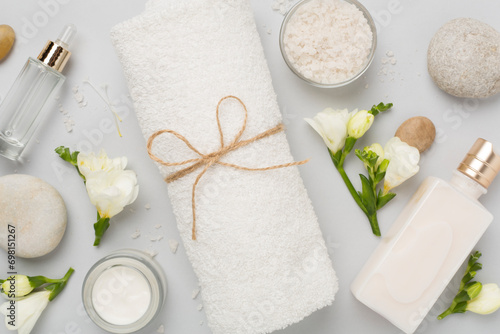 Flat lay with spa products and flowers on color background photo