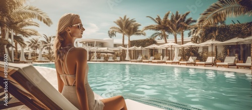 woman relaxing by the swimming pool in a luxury hotel photo