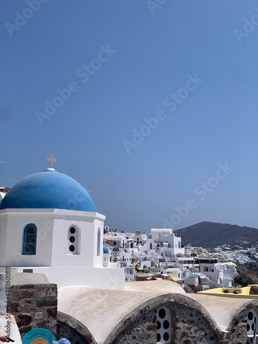 Beautiful Oia town on Santorini island, Greece. Traditional white architecture and greek orthodox churches with blue domes over the Caldera, Aegean sea in the beautiful town of Oia. 