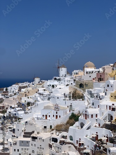 Beautiful Oia town on Santorini island, Greece. Traditional white architecture and greek orthodox churches with blue domes over the Caldera, Aegean sea in the beautiful town of Oia. 