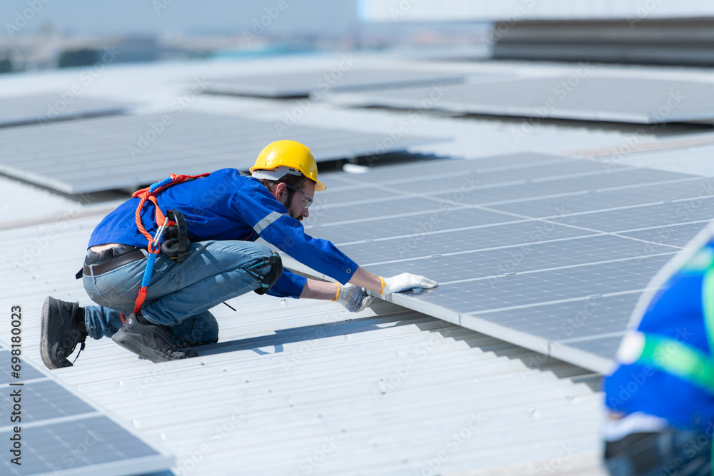Both of technicians is installing solar panels on the roof of the warehouse to change solar energy into electrical energy for use in factories. Both of technicians is installing solar panels on the roof of the warehouse to change solar energy into electrical energy for use in factories.