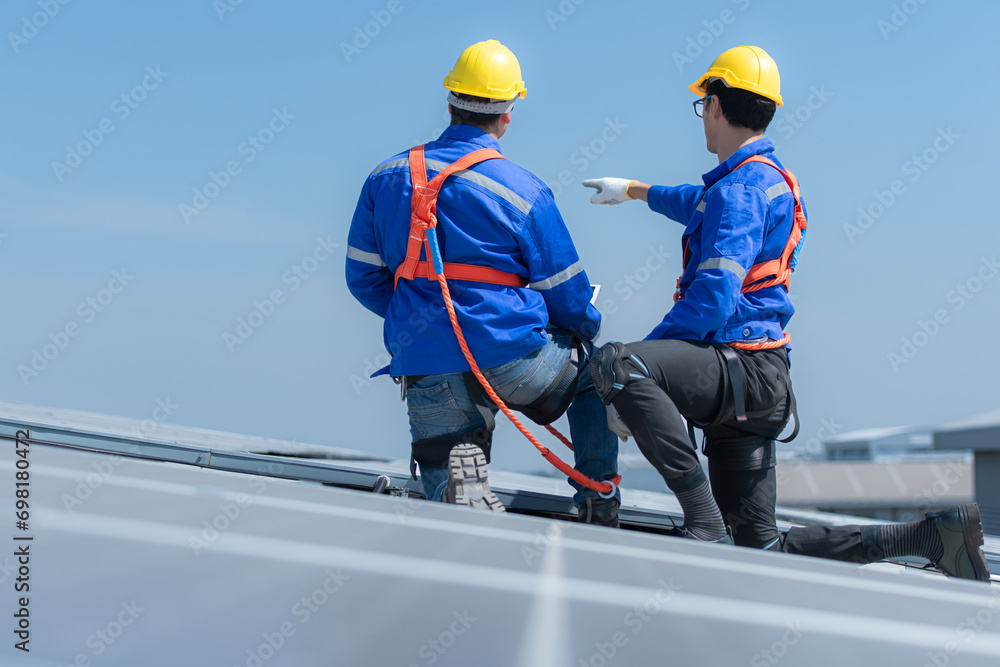 Both of technicians is installing solar panels on the roof of the warehouse to change solar energy into electrical energy for use in factories. Both of technicians is installing solar panels on the roof of the warehouse to change solar energy into electrical energy for use in factories.