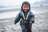 Inuit boy running joyfully on snowy beach in cold weather
